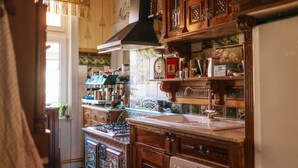 Una cocina tradicional con armarios de madera, estufa y diversos utensilios de cocina.