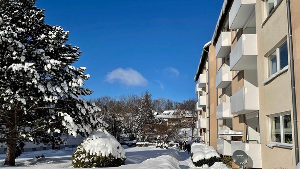 A snow-covered residential area with a building featuring balconies and a clear blue sky. - Bergfürst bed linen bookable - Bergfürst (Bad Harzburg)