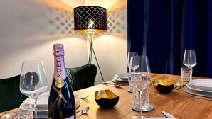 A dining table with a bottle of Moët & Chandon champagne, wine glasses, cutlery, and a decorative bowl. - Bergfürst bed linen bookable - Bergfürst (Bad Harzburg)