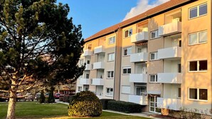 A multi-story apartment building with balconies, a lawn, and a large tree. - Bergfürst bed linen bookable - Bergfürst (Bad Harzburg)
