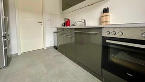 A modern kitchen with stainless steel appliances, a built-in oven, and a coffee maker on the countertop. - Bergfürst bed linen bookable - Bergfürst (Bad Harzburg)