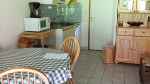 Ett kompakt kök med mikrovågsugn, spis och träskåp.
