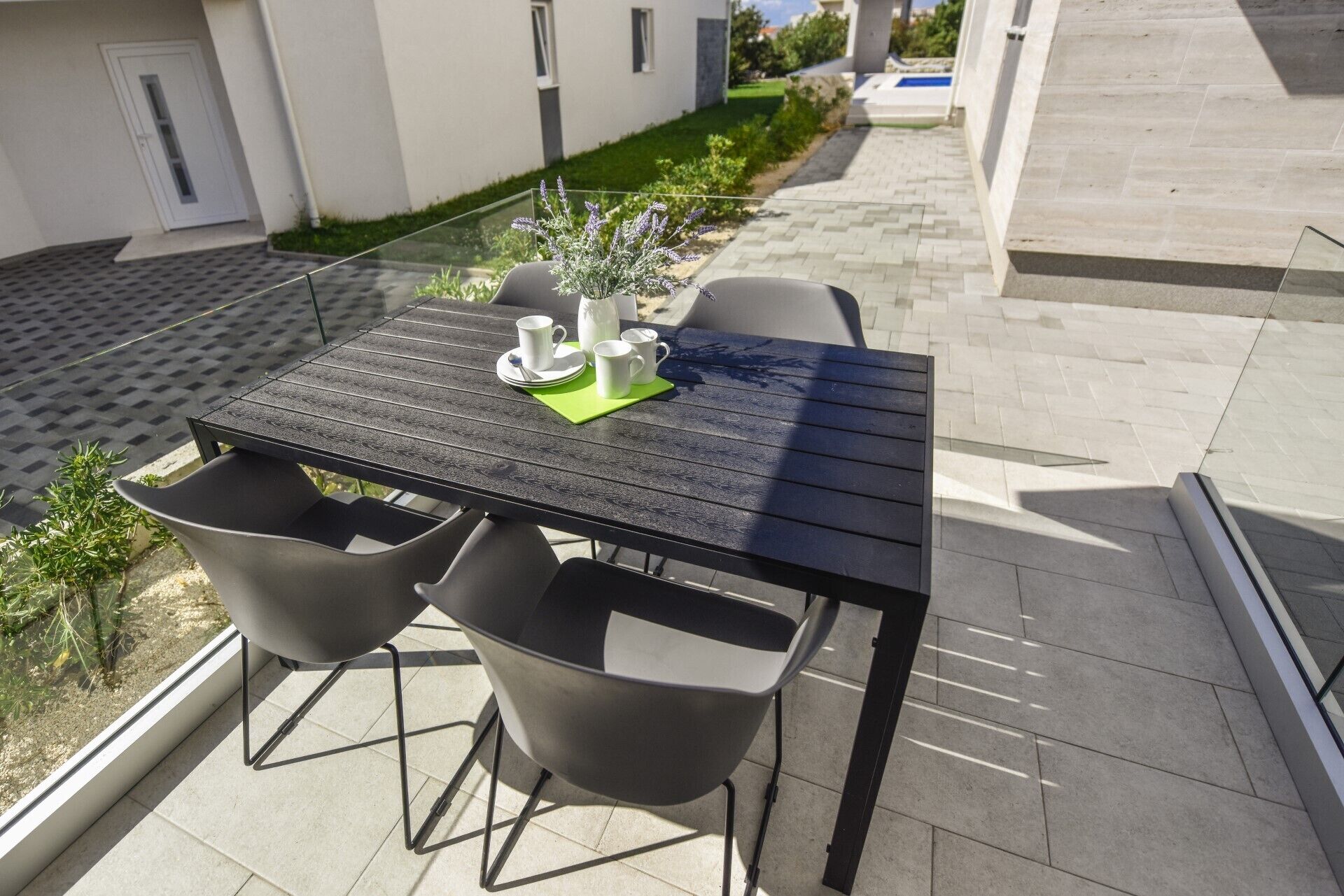 An outdoor patio with a table and chairs, a small plant, and a clear view of the surrounding area.