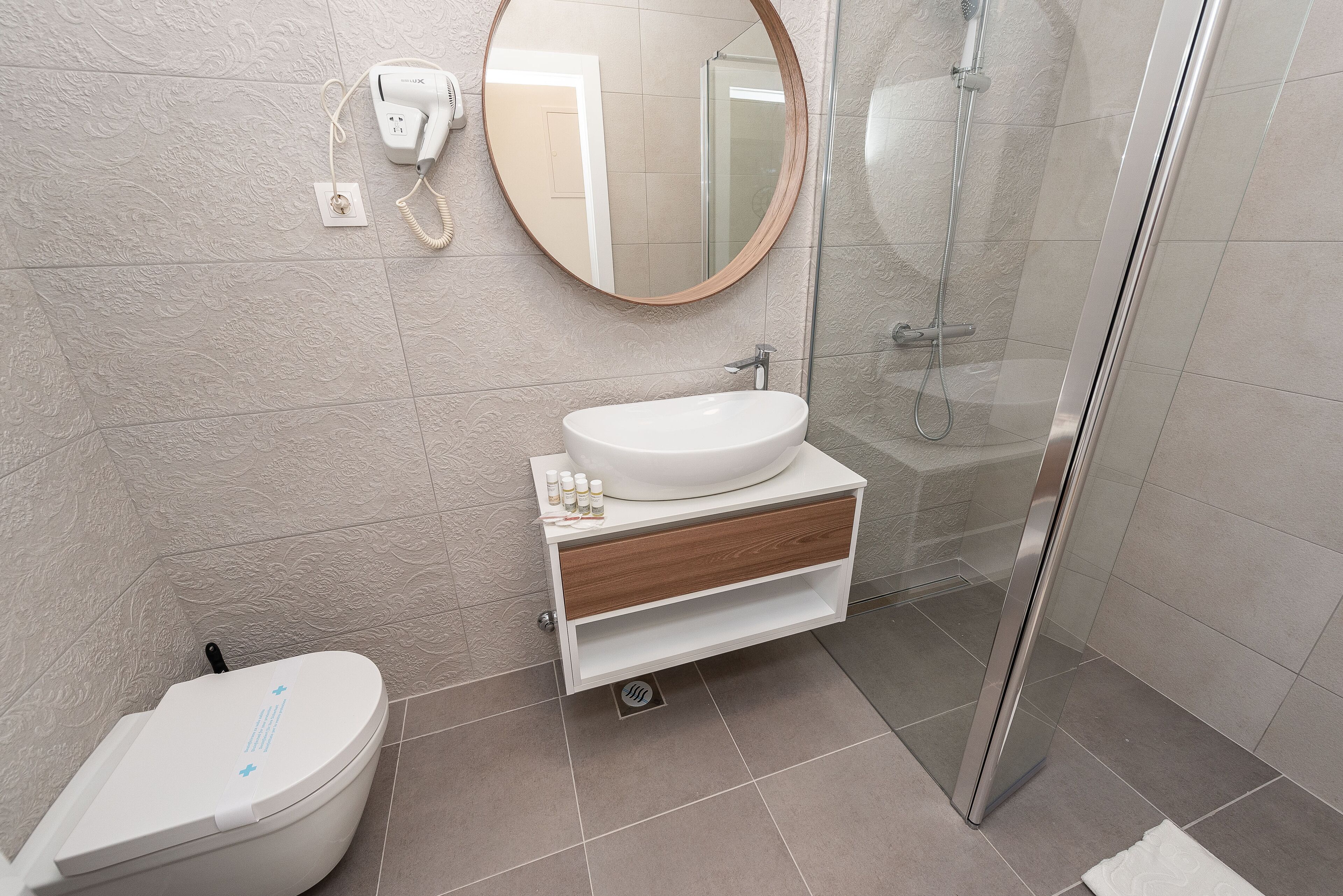 Une salle de bain avec des toilettes, un lavabo et une douche.