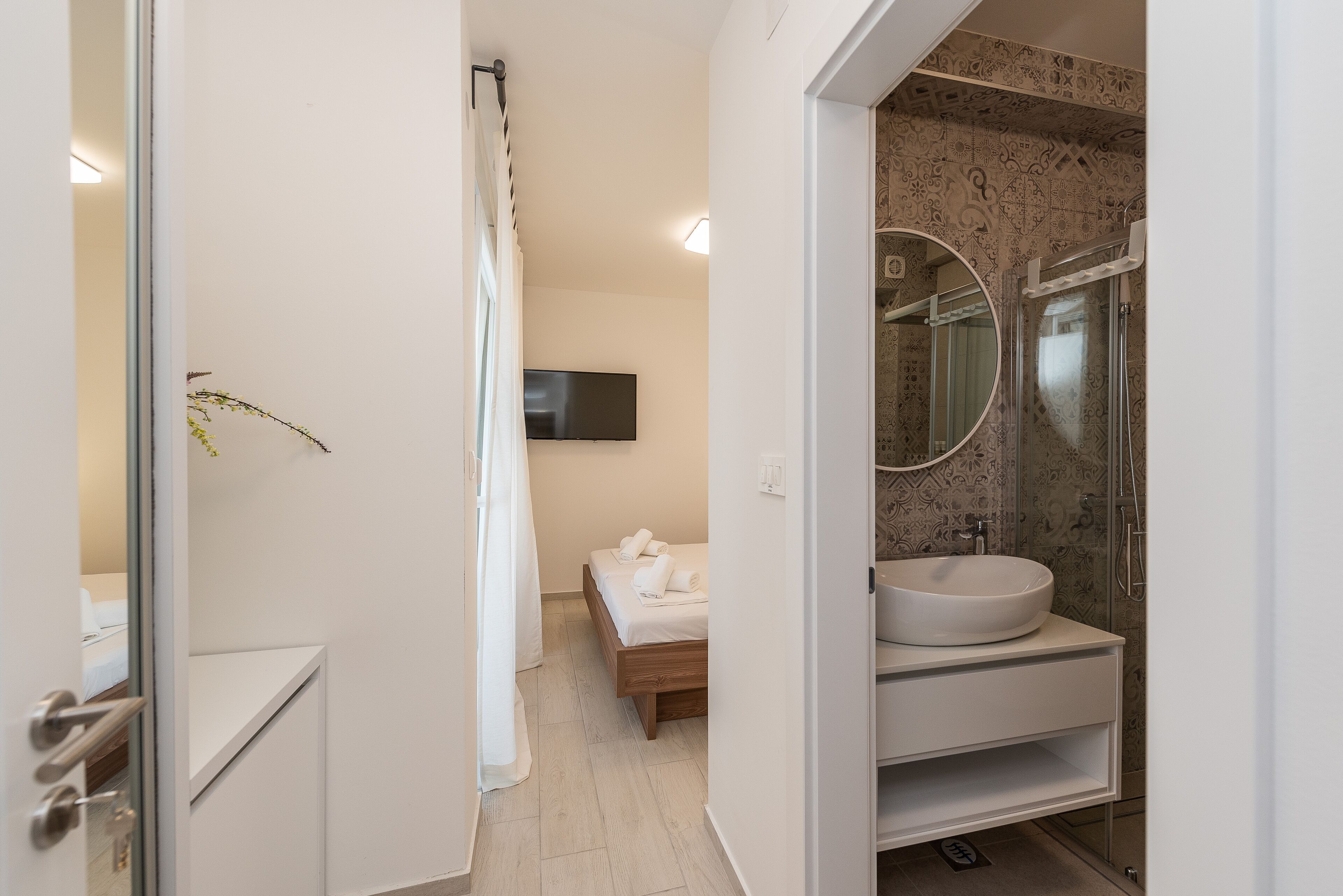A modern bathroom with a large sink, a mirror, and a shower.