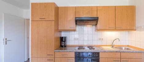 Een koelkast, een oven, een koffiezetapparaat/waterkoker, een waterkoker