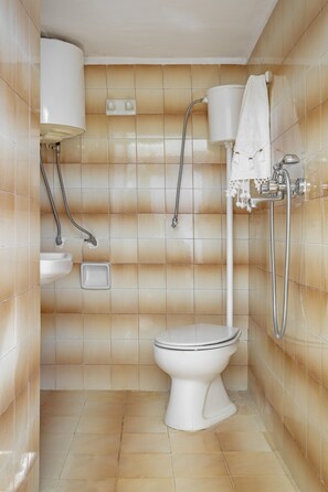 Ein Badezimmer mit Toilette, Waschbecken und Dusche.