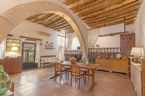Ein geräumiger Essbereich mit Holztisch und -stühlen, einer großen Vase sowie eine rustikale Küche mit Holzausstattung und einer Hängeleuchte.