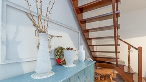 Eine Treppe mit Holzgeländern und einem blauen Schrank mit Dekorationselementen.