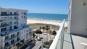 Un edificio alto con varios balcones que dan a una playa.