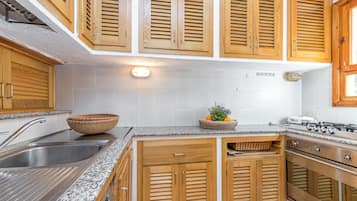 Apartamento família, vários quartos, 2 banheiros (Piazzetta Villa Roxy 10m From) | Cozinha privada | Geladeira, micro-ondas, fogão, cooktop