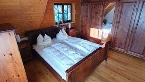 Un dormitorio con paneles de madera, una cama, una mesita de noche y un armario.