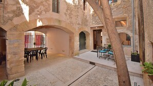 An interior courtyard with stone walls, a wooden table with chairs, and a small seating area with a table and chairs. - 252 Casa Alcariot VT/107415 by Mallorca Charme (Arta)