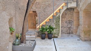 An interior courtyard with stone walls, a staircase, and potted plants. - 252 Casa Alcariot VT/107415 by Mallorca Charme (Arta)