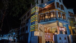 Un edificio de varios pisos con un balcón y un letrero que indica un restaurante.