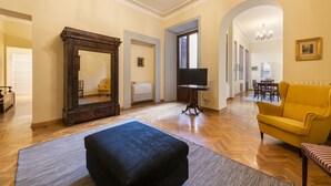 A spacious living room with a large mirror, a yellow sofa, and a black ottoman. - Duomo Luxury House by Mmega (Florence)