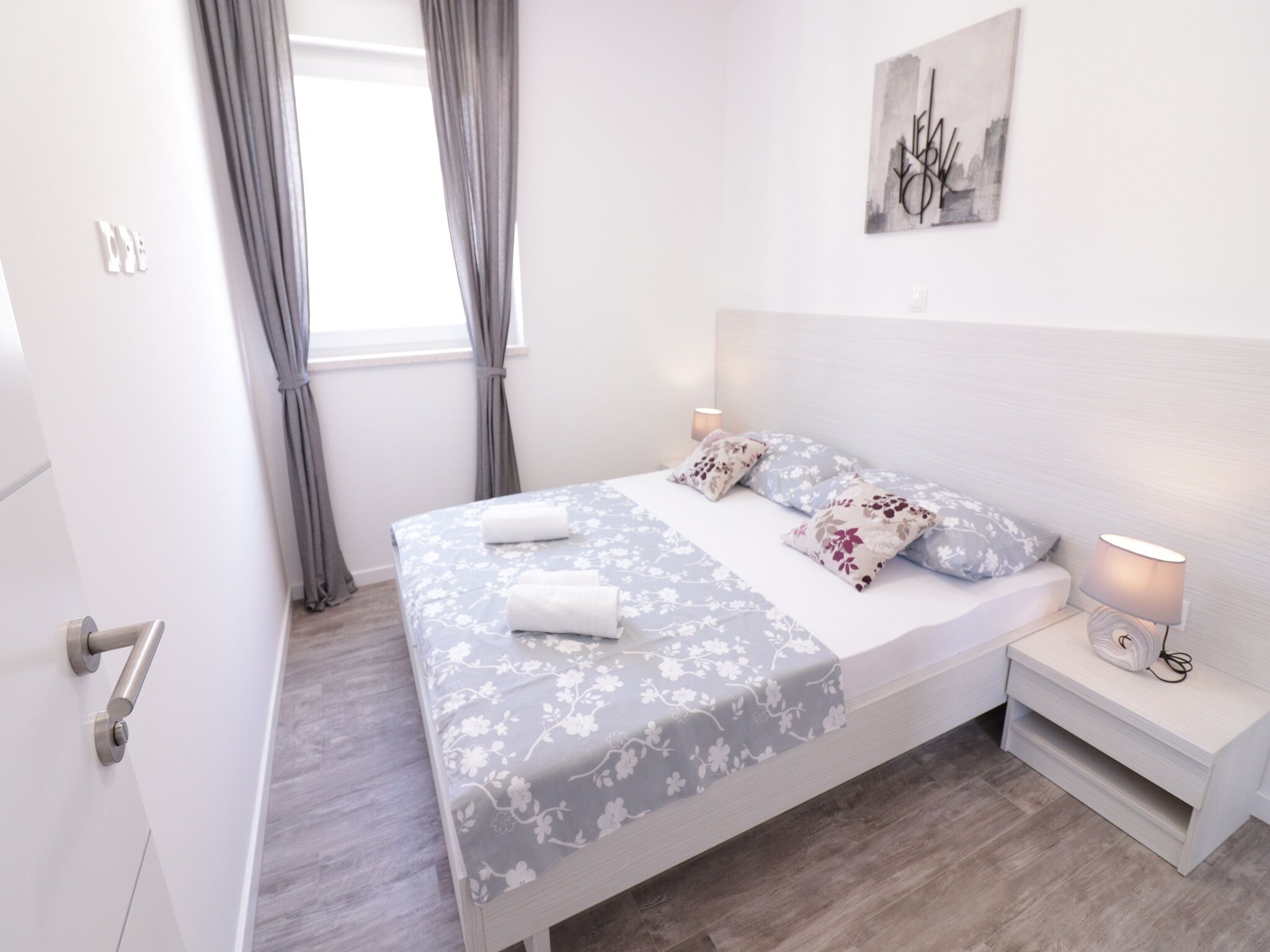 Une chambre moderne avec un lit, des tables de chevet et une fenêtre avec des rideaux.