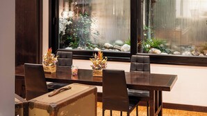 A dining area with a wooden table, leather chairs, and a decorative vase. -  Phi Hotel Bologna Apartments (Bologna)
