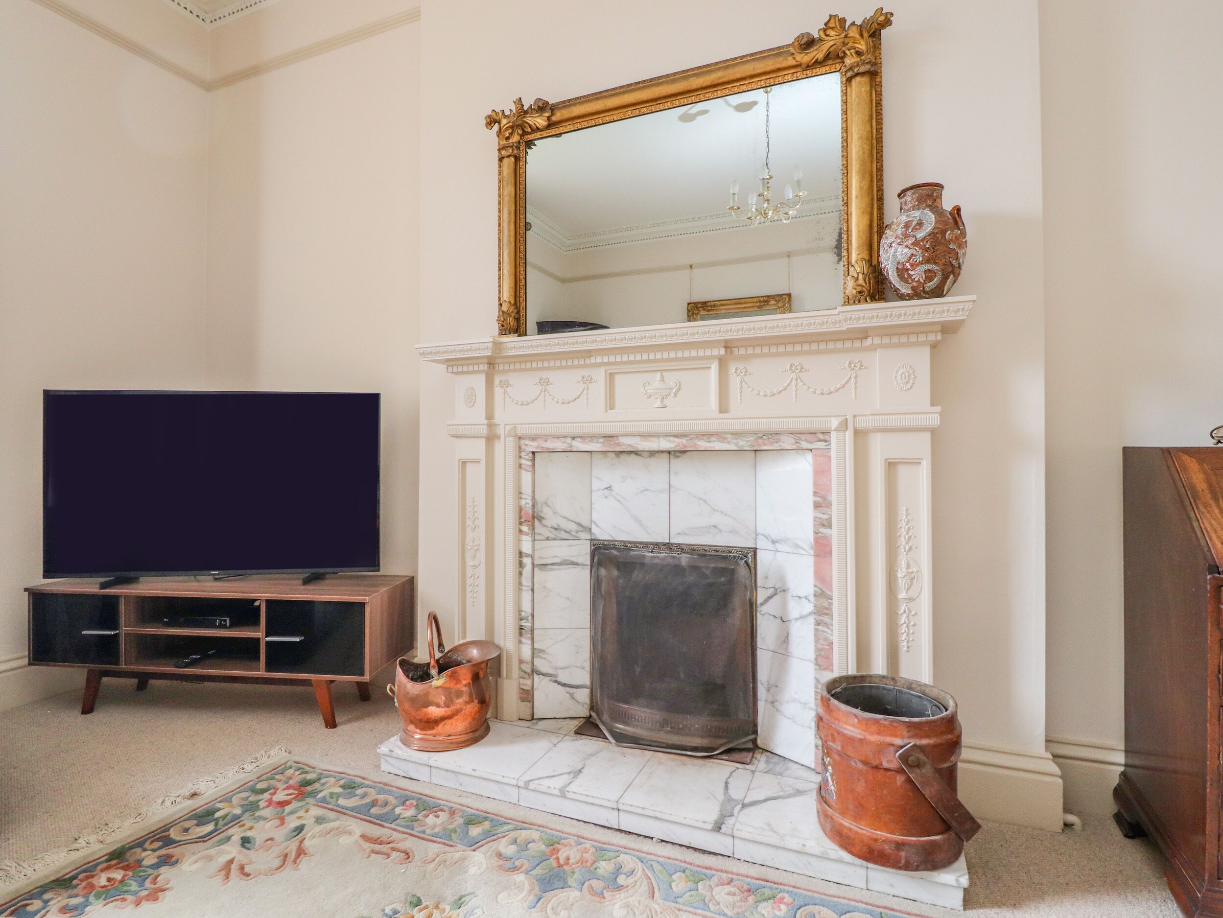 Ein Wohnzimmer mit Fernseher, Kamin und Dekoration.