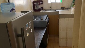 Appartement Affaires | Cuisine privée | Réfrigérateur, micro-ondes, batterie de cuisine, vaisselle et ustensiles