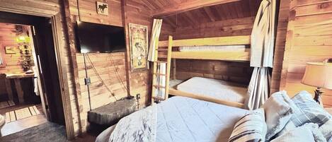 A wooden cabin room with bunk beds, a ceiling fan, and a mounted TV.