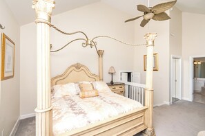 A four-poster bed with a canopy, a bedside table, a lamp, and a framed picture on the wall. - @ The Beach - 7BR Oceanfront Home in Hampton Colony (North Topsail Beach)