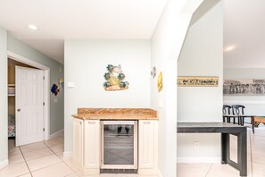 A kitchen with a built-in oven, a decorative fish wall art, and a vintage photo on the wall. - @ THE PEACH offers an escape to an oceanfront/oceanside (North Topsail Beach)
