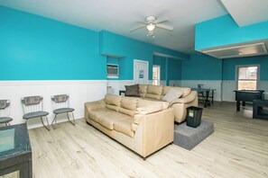 A spacious living room with a beige sectional sofa, a ceiling fan, and a view of a dining area. - @ THE PEACH offers an escape to an oceanfront/oceanside (Sneads Ferry)
