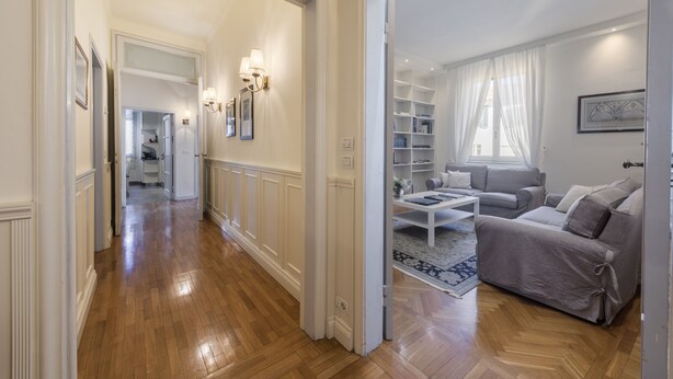 A spacious living area with a sofa set, a coffee table, and a bookshelf.