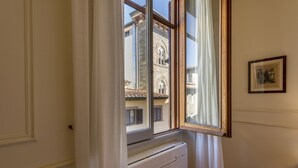 A room with a window overlooking a building with a tiled roof.