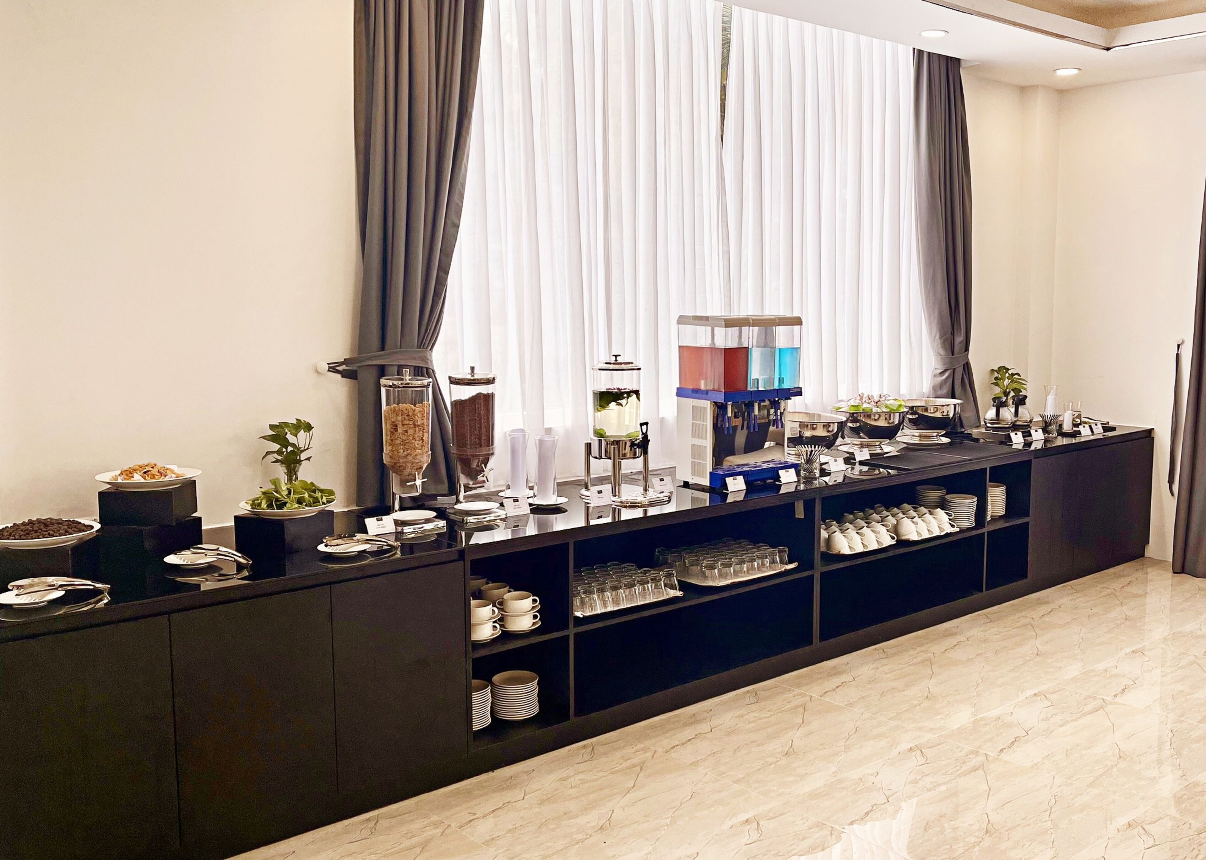 Montaje de buffet con diversas opciones de comida y una máquina de café.