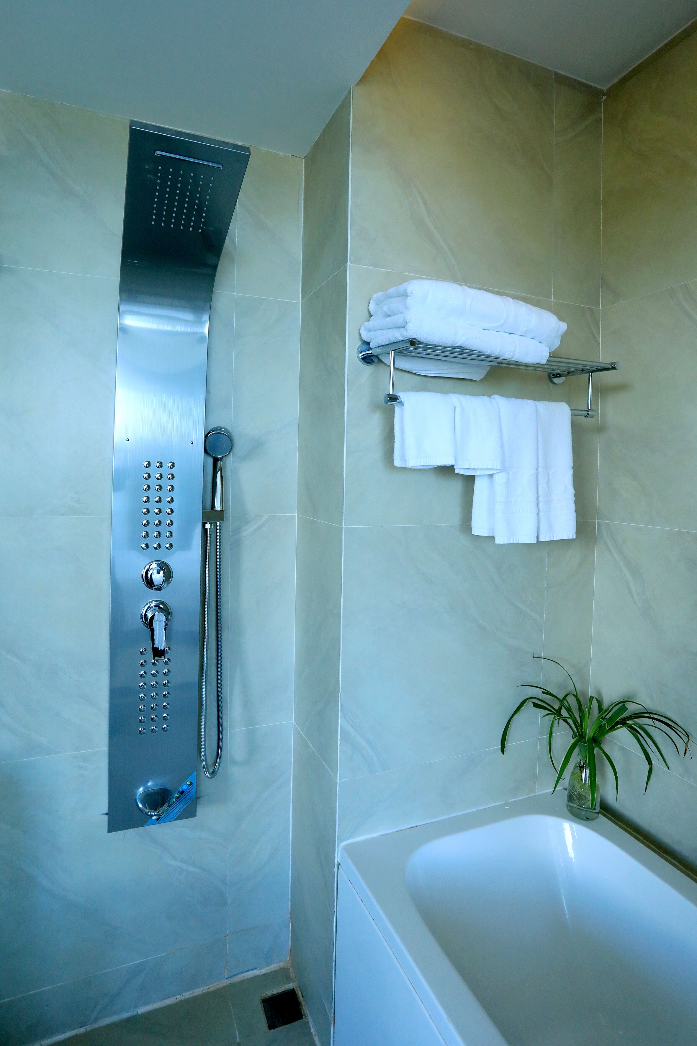 Une salle de bain moderne équipée d’une douche, d’une baignoire et d’un porte-serviettes.