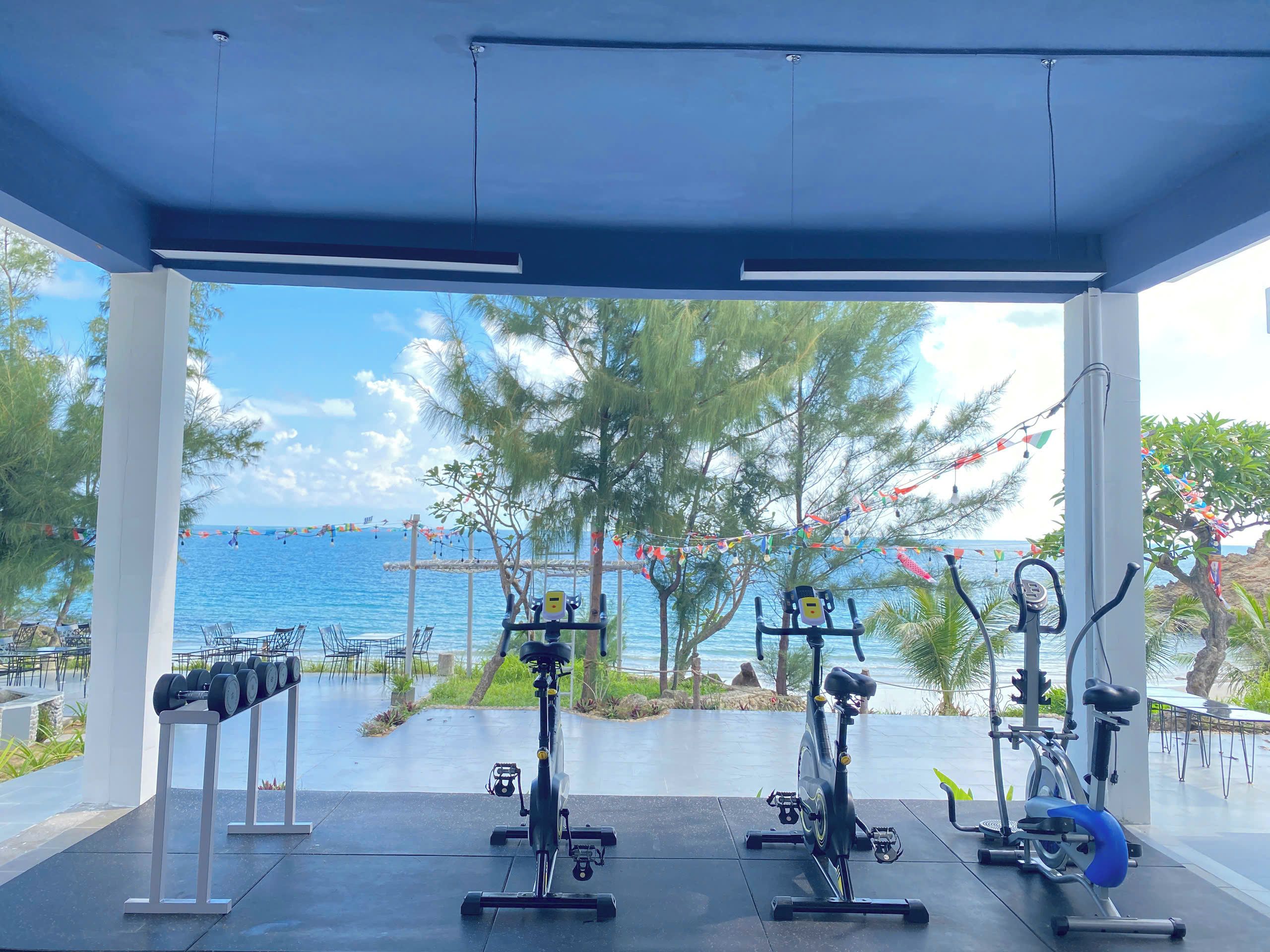 An outdoor gym area with exercise equipment and a view of the sea.