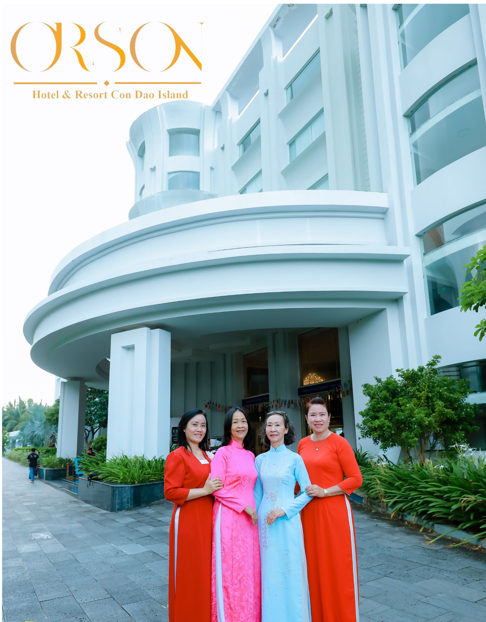 A group of people standing in front of a modern hotel building with a curved entrance.