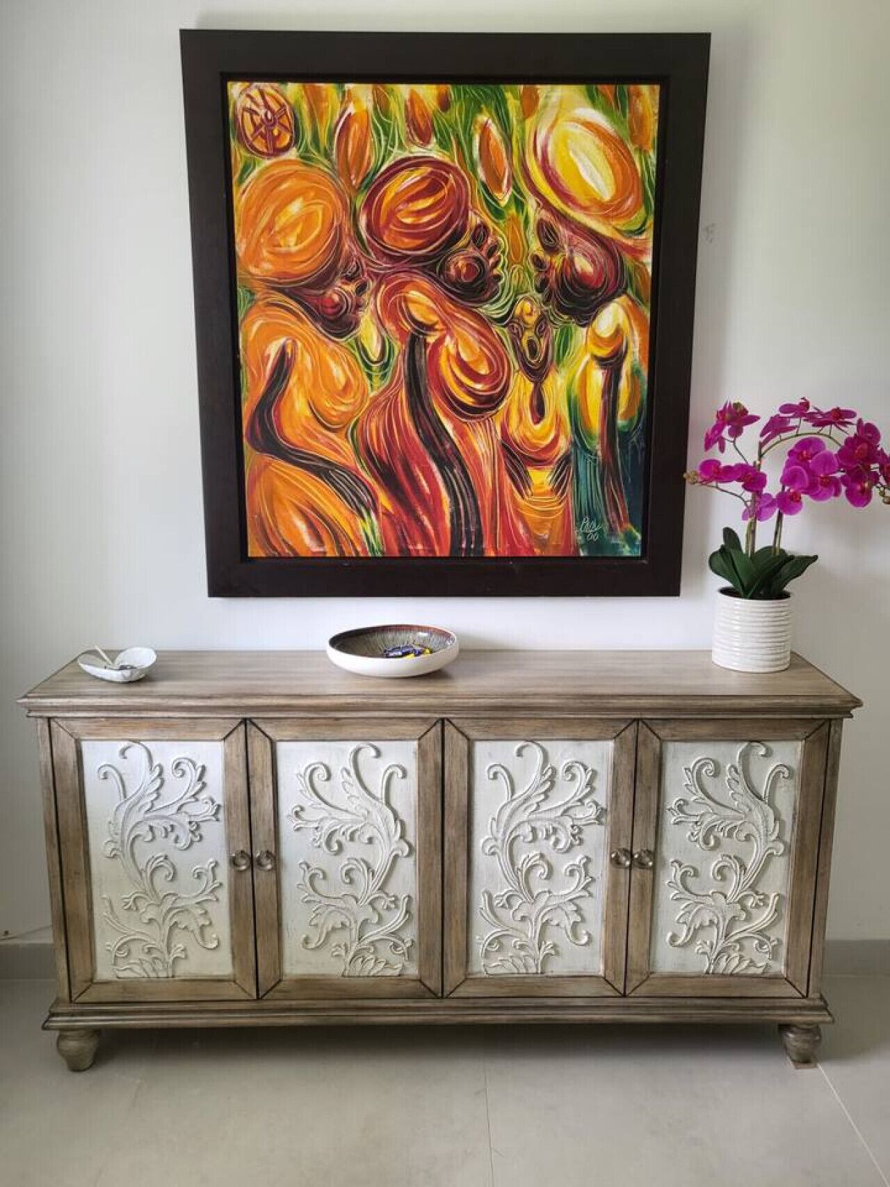 Una pintura de patrones arremolinados y un aparador con delicados grabados.