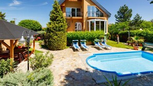 A two-story house with a swimming pool, a covered patio, and a well-maintained garden. - Vacation home Szabo by Interhome (Balatonlelle)