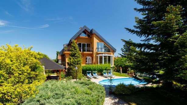 A two-story house with a swimming pool, surrounded by greenery and a stone pathway. - Vacation home Szabo by Interhome (Balatonlelle)