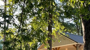 Une terrasse en bois avec une rambarde, un porche couvert et des fondations en pierre.