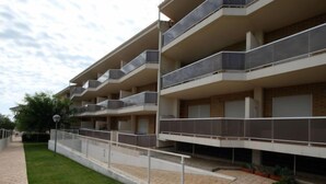 A multi-story residential building with balconies, a paved walkway, and a small garden area. - Residencial Mar I by Interhome (Alcanar)