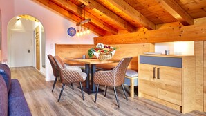 Ein gemütlicher Essbereich mit Holzboden, einem Tisch mit Stühlen und einer Küchenarbeitsplatte mit Schränken.