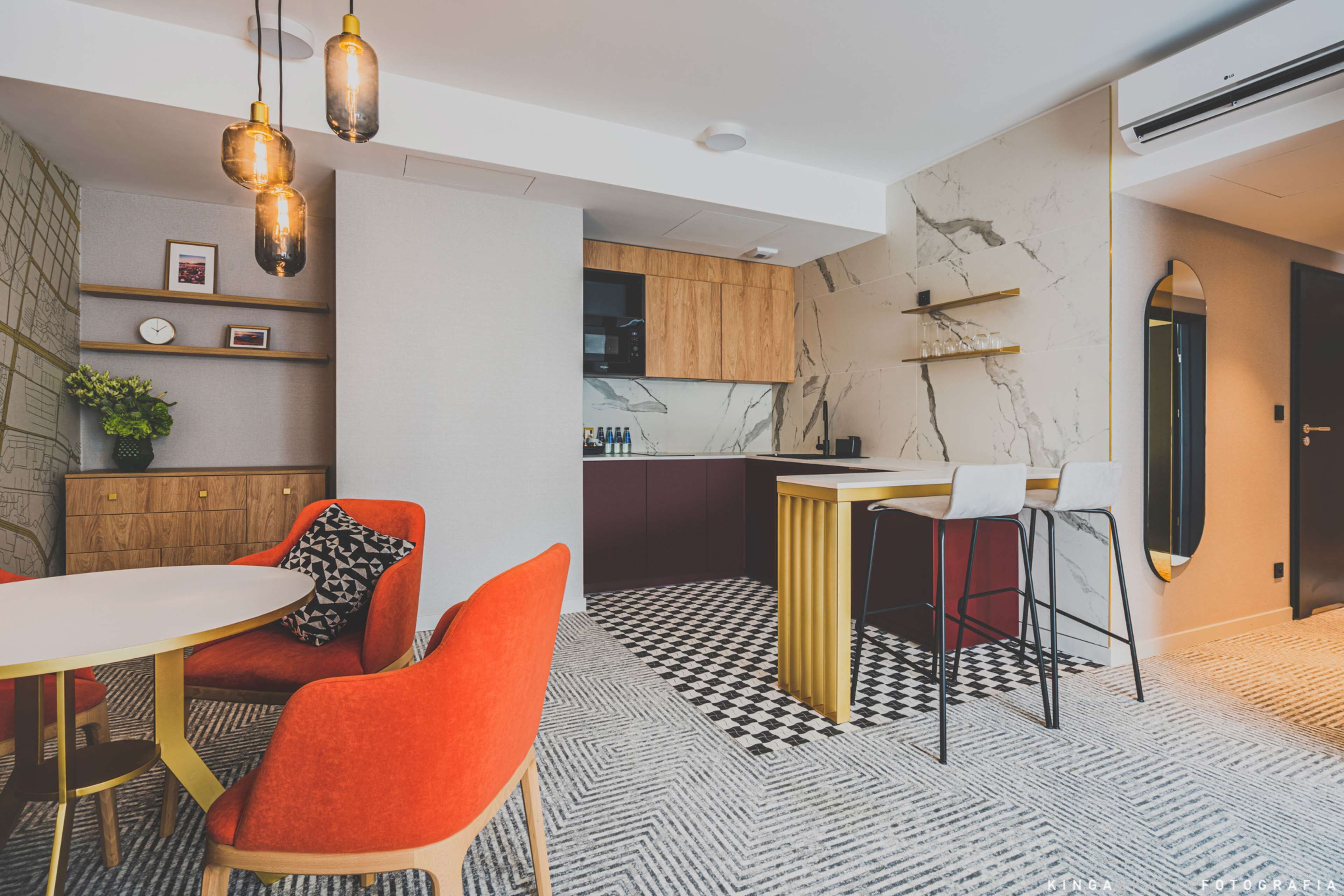 A modern kitchen with marble backsplash, wooden cabinets, and a bar area.