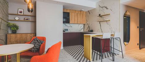Una cocina moderna con salpicadero de mármol, armarios de madera y una zona de bar.