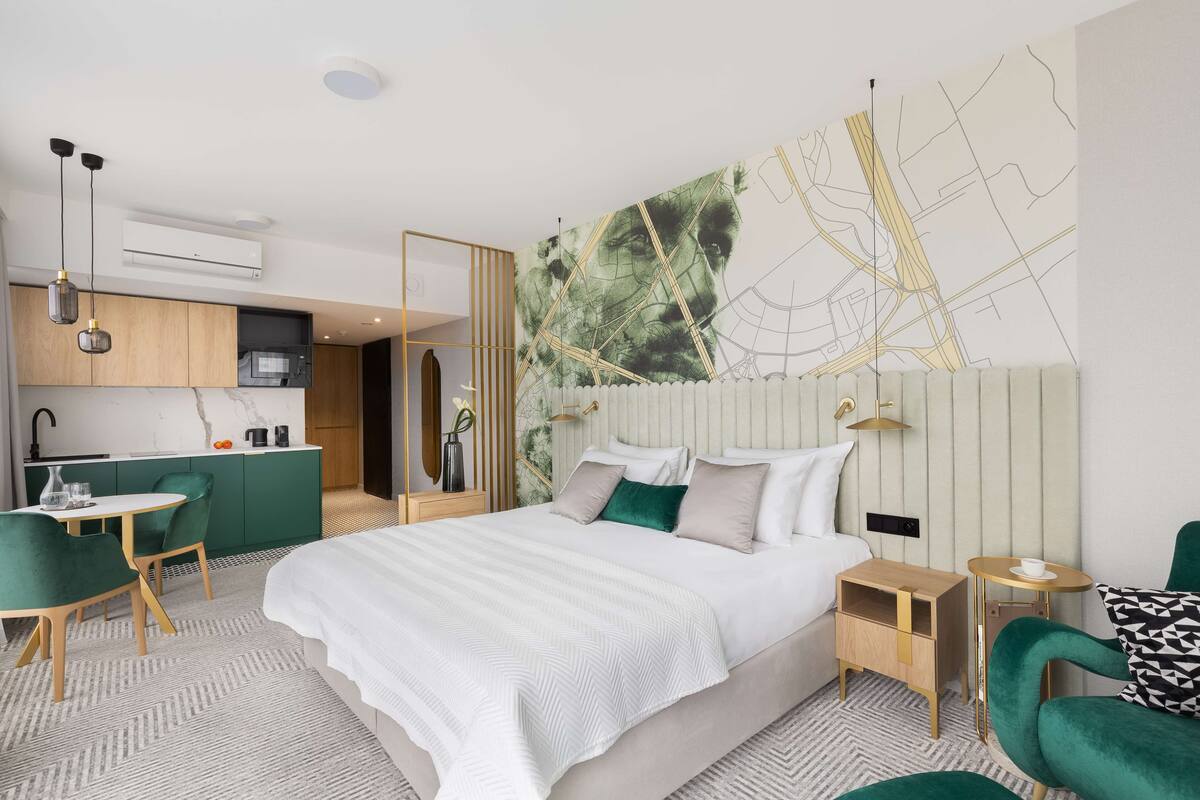 Una habitación de hotel moderna con una cama grande, un comedor y una cocina.