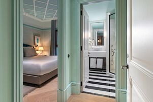 A bedroom with a bed, bedside lamp, and a framed picture on the wall.