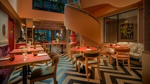 Un interior moderno con una escalera en espiral, comedor y diferentes disposiciones de asientos.