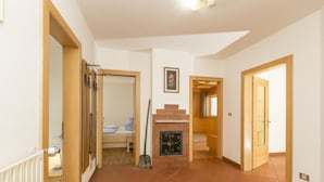 A hallway with a fireplace, a radiator, and a bed in the background. - Valle Aurina, Appartement Sonneck Möseler (Lappach)