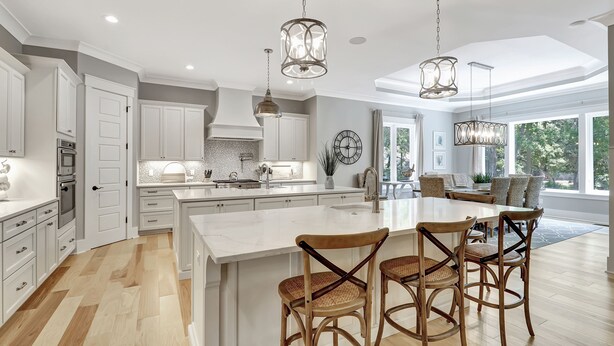 A spacious kitchen with white cabinetry, a large island, and hanging pendant lights. - Brand New Construction 3rd Row Home in Palmetto Dunes! (Hilton Head Island)