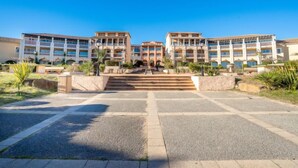 Un hotel con un cortile interno, diversi balconi e un cielo azzurro.