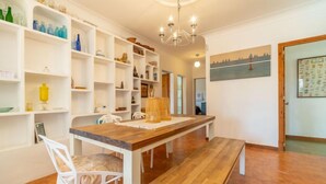 A dining area with a wooden table and benches, surrounded by white shelves with various items. - Can Xiroia by Interhome (Port d'Alcúdia)