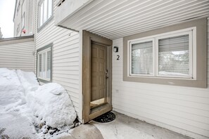 Welcome to a cozy home with a front door and windows, featuring a doormat at the entrance.
